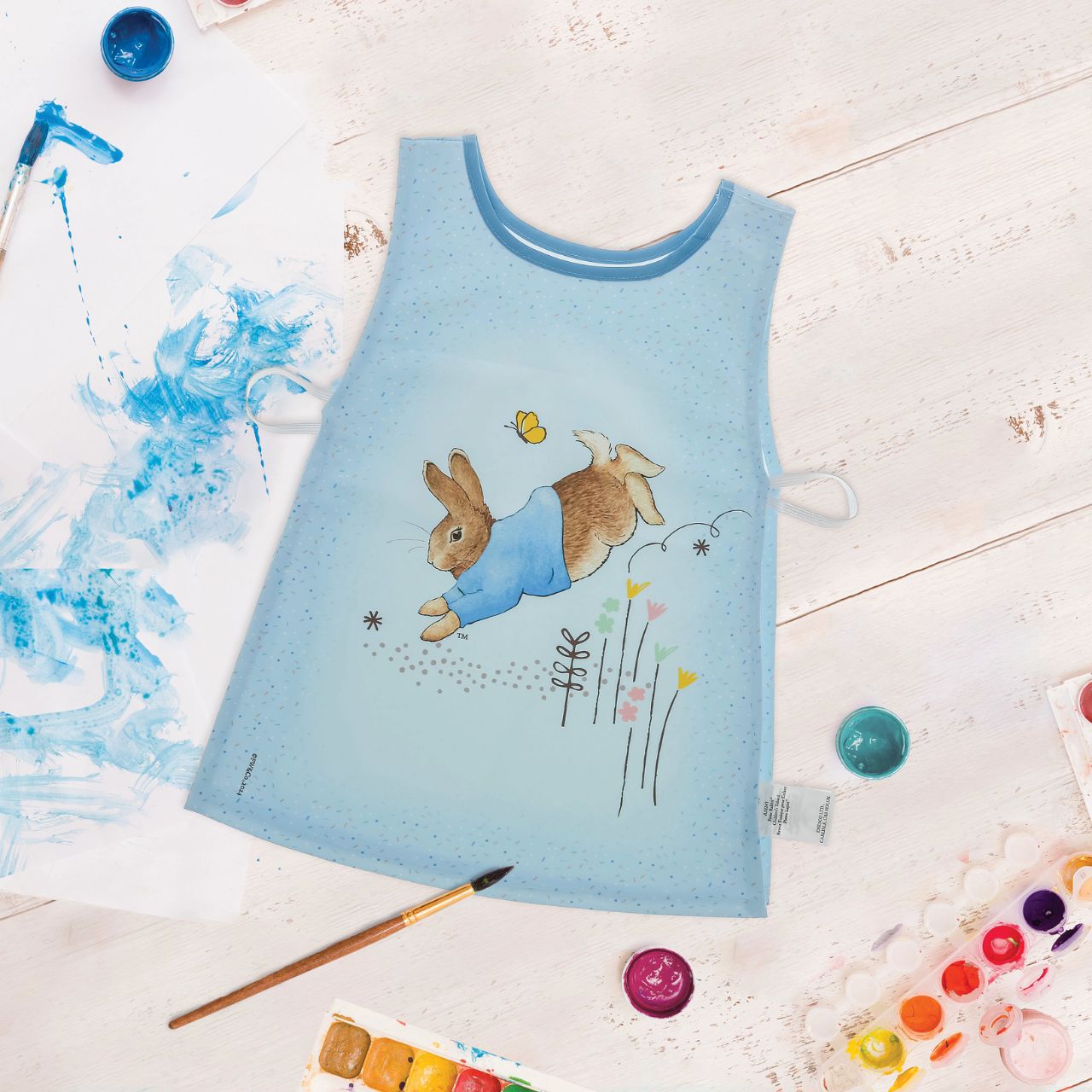 Introducing the charming Peter Rabbit Tabard, designed with both style and practicality in mind. Featuring hook & loop tape fastening at the neck and elasticated sides, this bib is easy to put on and adjust, ensuring a snug fit for your little one.