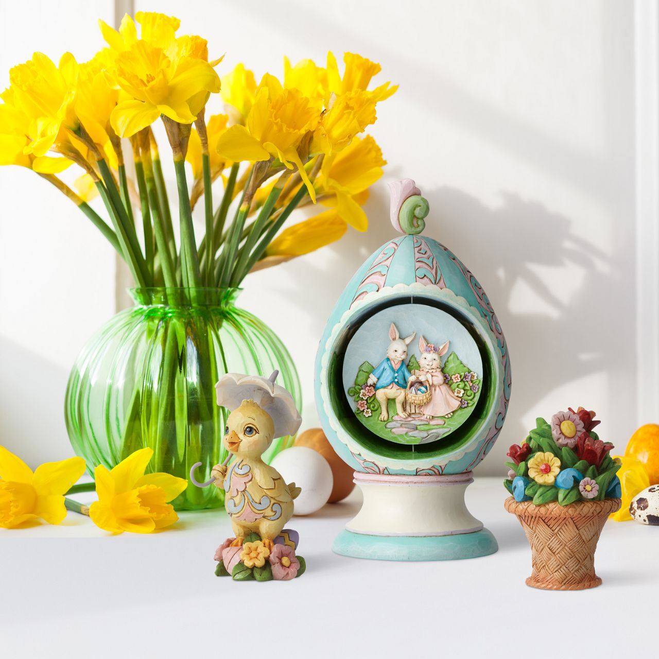 Revolving Egg with Bunnies and Chicks Scene Figurine by Jim Shore Stroll through Spring with this festive Jim Shore tabletop Easter egg. Simply turn the floral finial atop the egg to rotate the scene inside between two adorable Easter scenes. Chicks soak in the sun while a pair of bunnies jubilantly collect eggs.