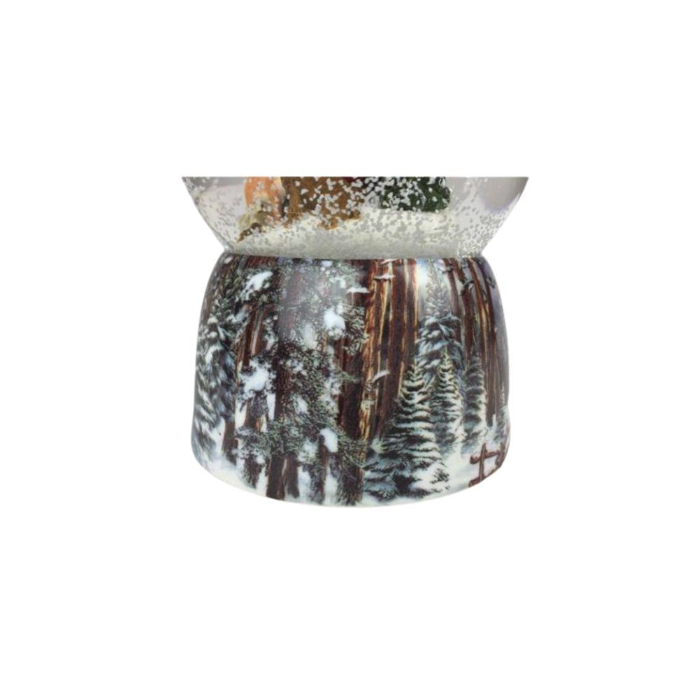 Snow globe Santa in the forest. Santa sits in the globe filled with snow between a few wild animals and feeds them between the snowy fir trees. The base is painted with snowy forest scenes.