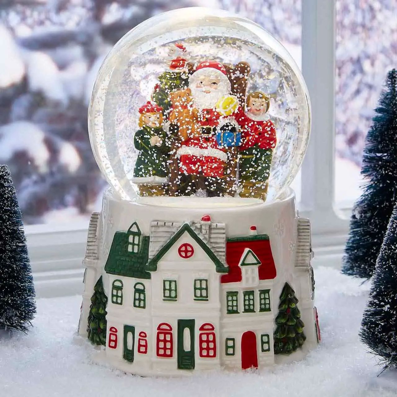 Step into a winter wonderland with this enchanting Christmas Tre Village Snow globe from Spode. Inside the glass globe, Santa Clause, laden with gifts, delights a group of children in a scene of pure holiday magic.
