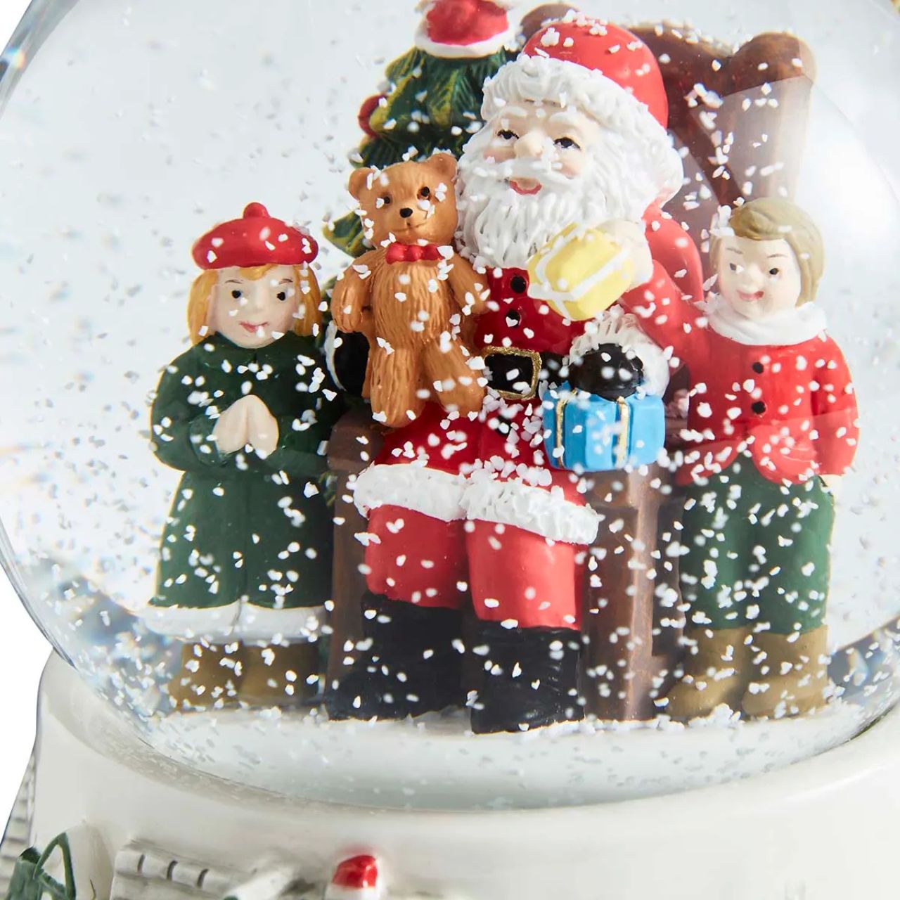 Step into a winter wonderland with this enchanting Christmas Tre Village Snow globe from Spode. Inside the glass globe, Santa Clause, laden with gifts, delights a group of children in a scene of pure holiday magic.
