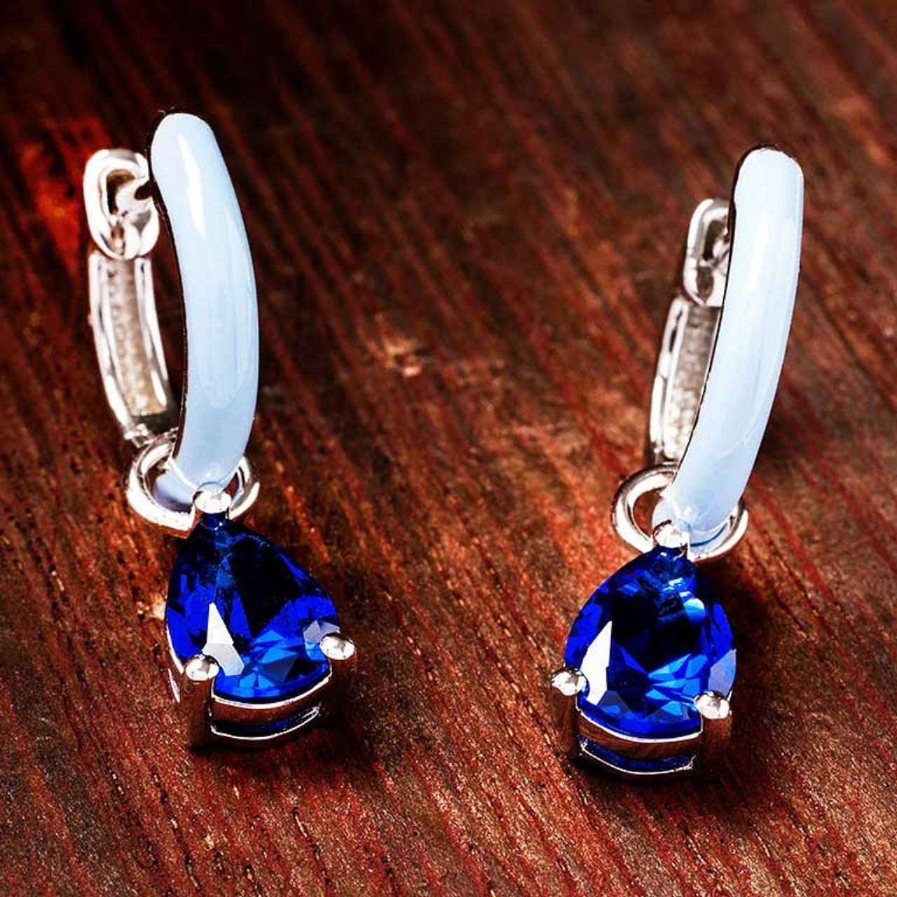 Elevate your elegance with ShanOre's Sterling Silver Drop Earrings, featuring brilliant sapphire cubic zirconia stones complemented by delicate blue enamel accents.
