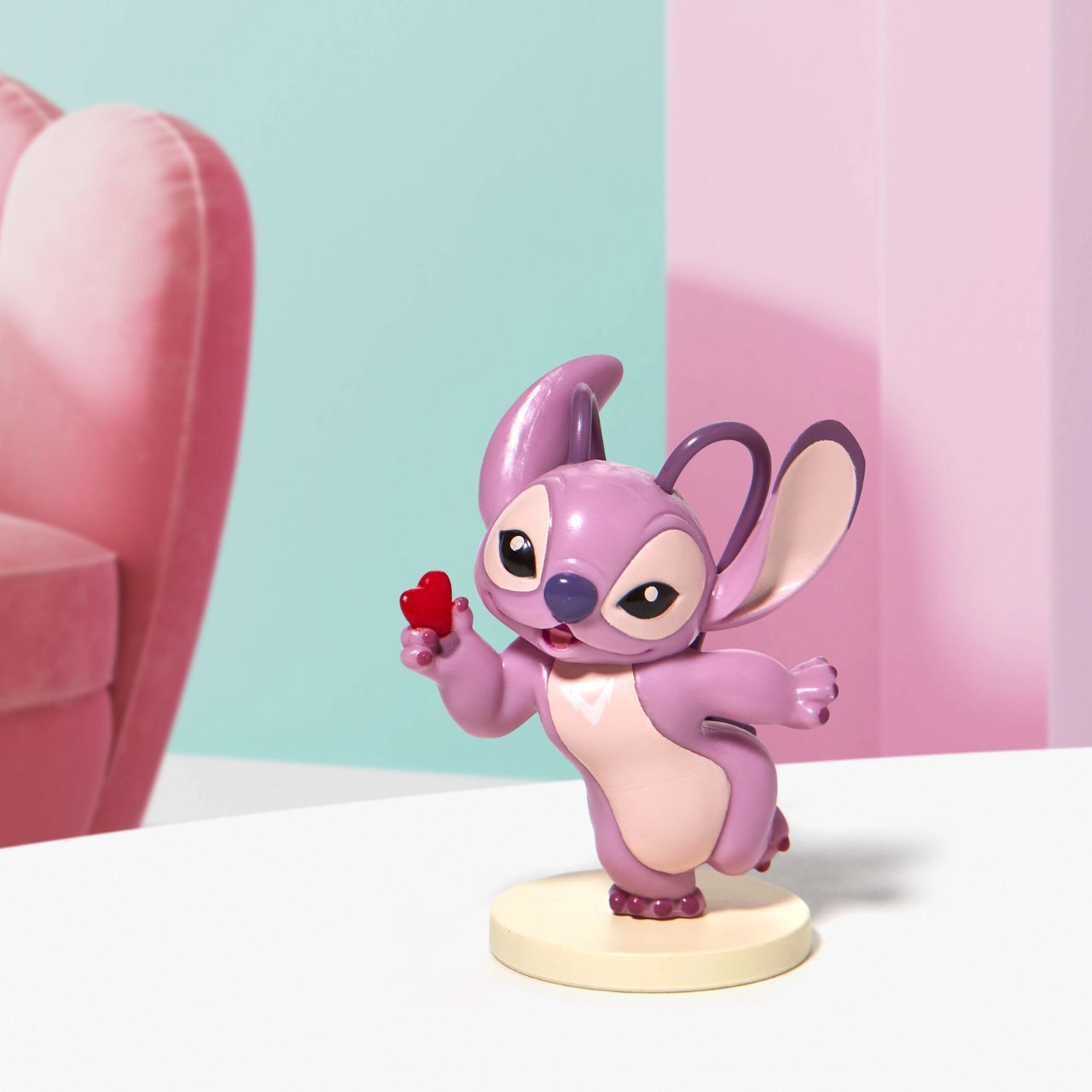 Stitch Angel with Heart Mini Figurine This super cute Angel mini figurine is holding a little red heart just for you. Angel is the girlfriend of Stitch and is sweet and loving. This is the perfect addition to any Stitch or Disney collection. Made from high quality vinyl.