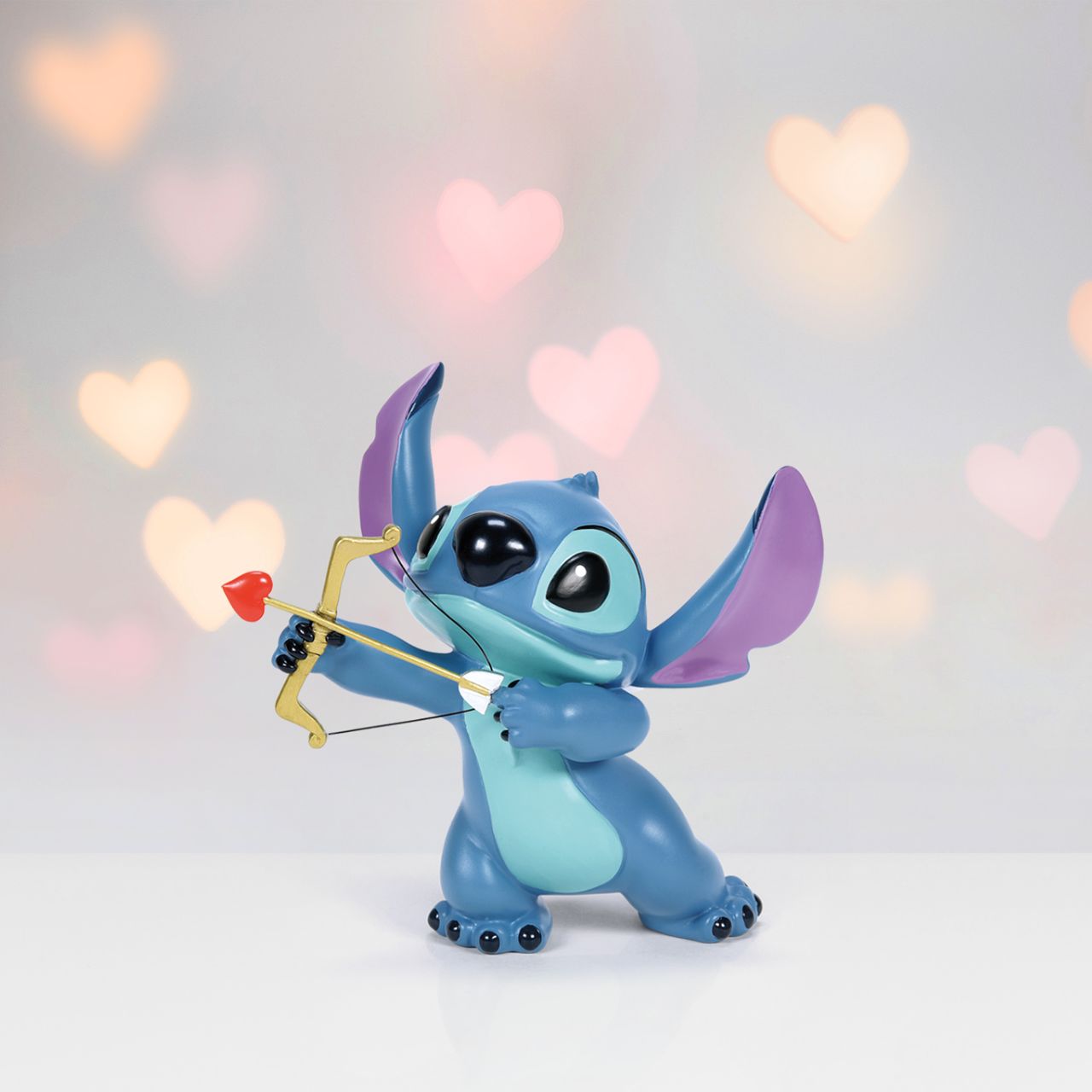 Meet our Stitch Valentine's Moment Figurine, the perfect blend of love and mischief. Handcrafted in vibrant detail, this piece features Stitch charmingly dressed as Cupid, wings and all. Sure to draw hearts and smiles, this romantic, whimsical piece is ideal for Disney fans or anyone yearning for a splash of enchantment.