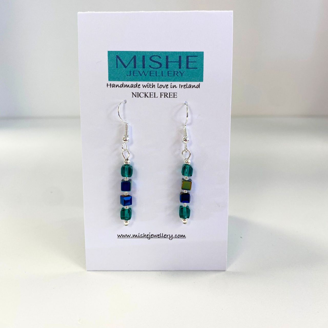 Faceted Crystal cubes in teal with an AB (Arora Borealis) finish coupled with blue Hematite and Blue faceted Crystal cubes. The earwires are nickel free silver plated.