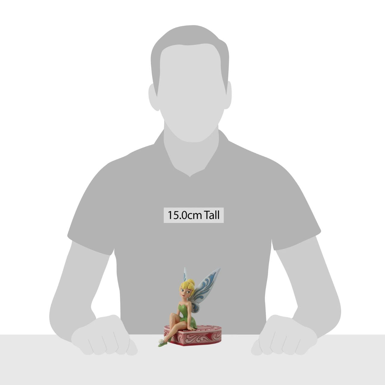 This fairy is sweeter than candy and sits on a heart-shaped box in this Jim Shore collectible. Tinkerbell, Peter Pan's sassy sidekick smiles coquettishly legs crossed daintily. With delicate rosemaling this fairy is in the love seat. Unique variations should be expected as this product is hand painted.