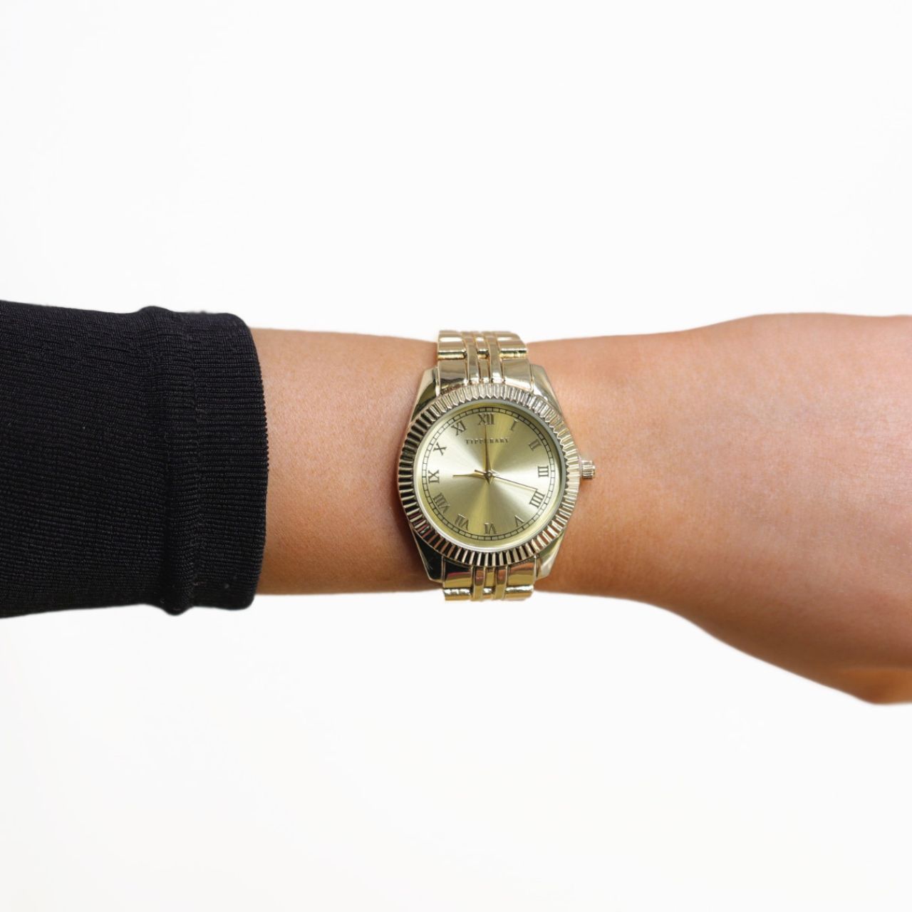 Crafted by the designers at Tipperary, The Enchanted Watch captures the essence of classic beauty with a warm, all-gold finish. Its lustrous gold dial features elegant Roman numeral hour markers, framed by delicate edge detailing that adds a subtle touch of sophistication.