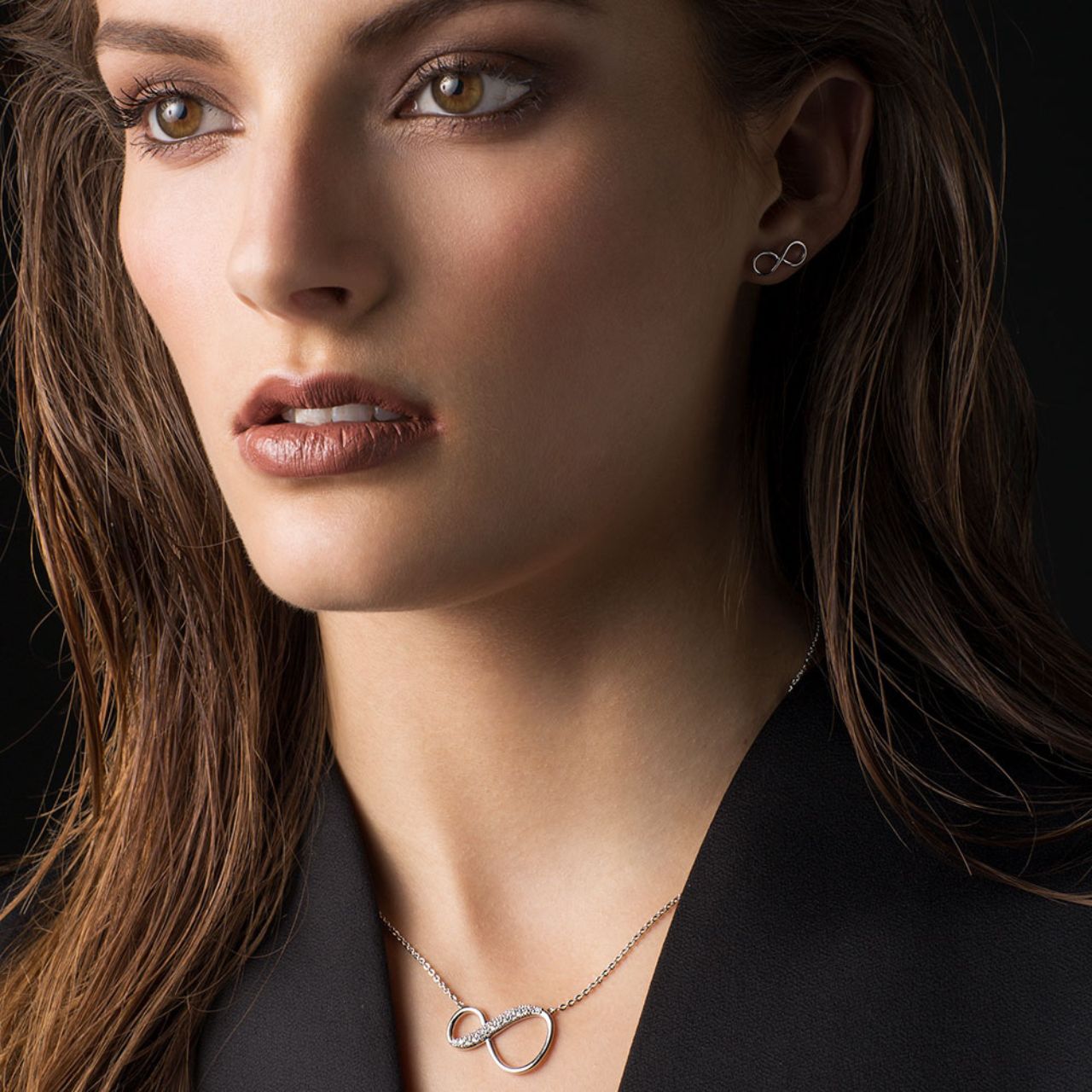 Express your never-ending love with this dazzling crystal adorned infinity pendant. The warm rose gold asymetrical infinity symbol is a sleek figure of eight with two rows of shimmering round clear crystal accents.