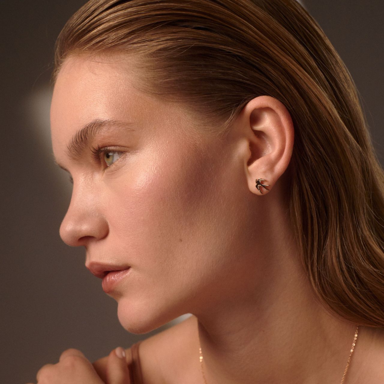 The Swallow Stud Earrings - Gold feature a delicate design of a swallow in mid-flight, symbolizing freedom and grace. These earrings add a subtle touch of elegance to any look. Their timeless design makes them perfect for both everyday wear and special occasions, offering a charming and sophisticated accent to your jewellery collection.