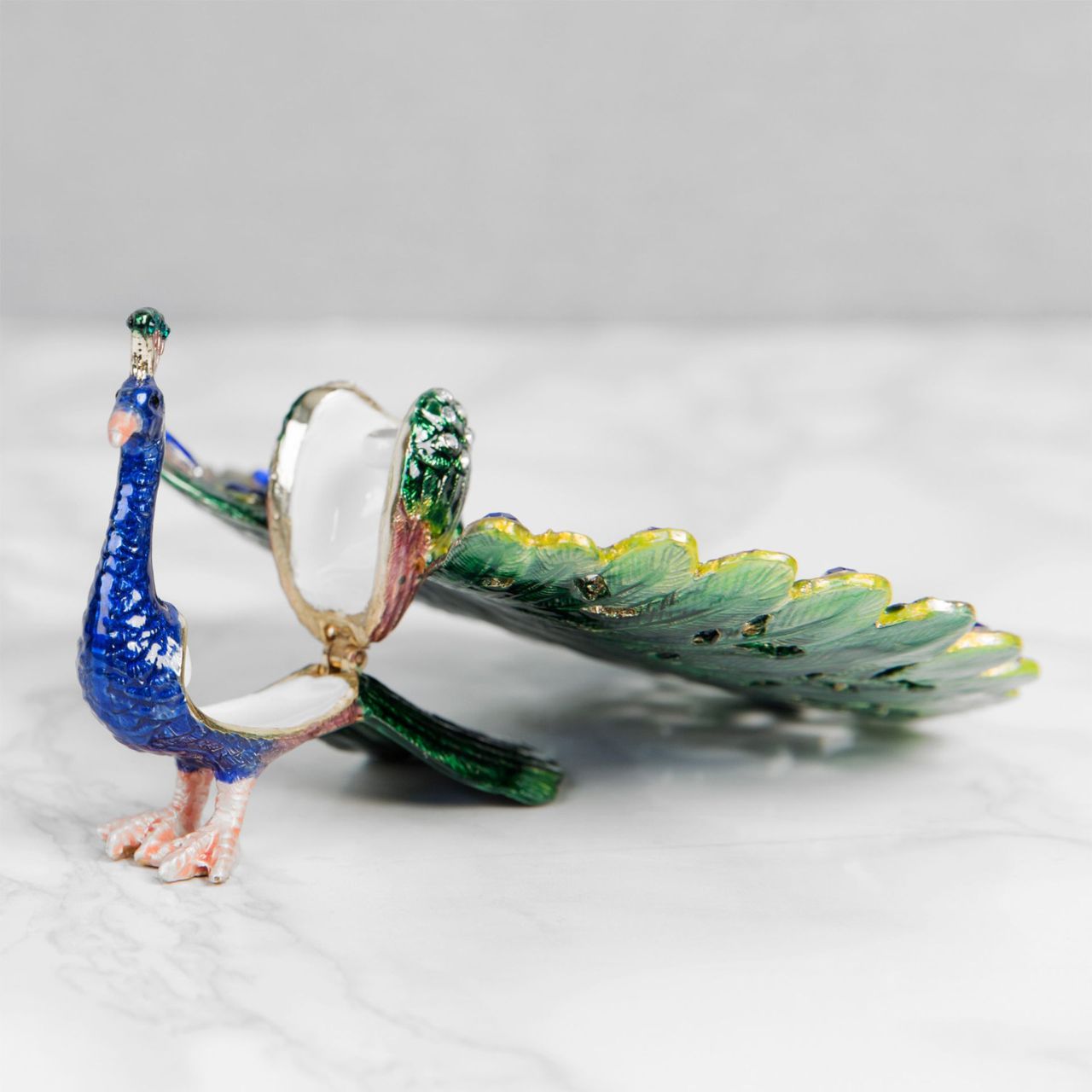 Painted in the glorious colours of a Peacock and its plumage, this peacock trinket with adorned with blue crystals that finish this wonderful ornament perfectly.