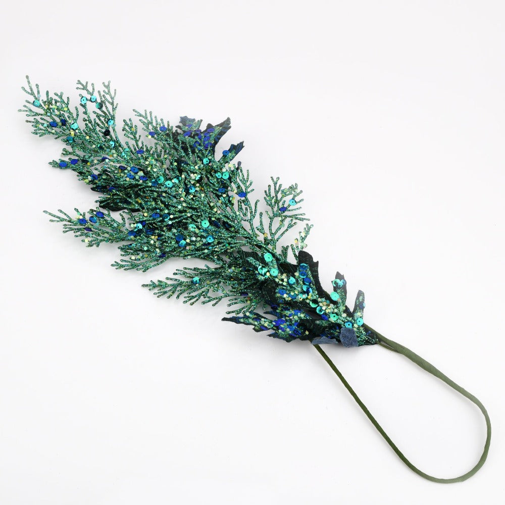 Blue Glitter Leaf Stem Christmas  Inspired by the grace and unique beauty of the peacock, Opulence guarantees a majestical and serene Christmas. With contemporary bold night colours and embellished gold foils, these luxury gifts bring the fairy-tale fantasy to life with their decorative textures and dazzling style.