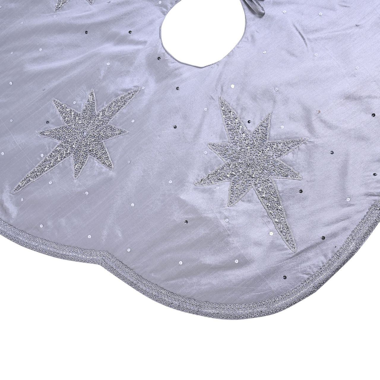 Christmas Tree Skirt with Scalloped Edge Silver Star Hand Embellished A silver star hand embellished Christmas tree skirt with scalloped edge. This standout accessory wraps itself around Christmas trees to accentuate its decoration.