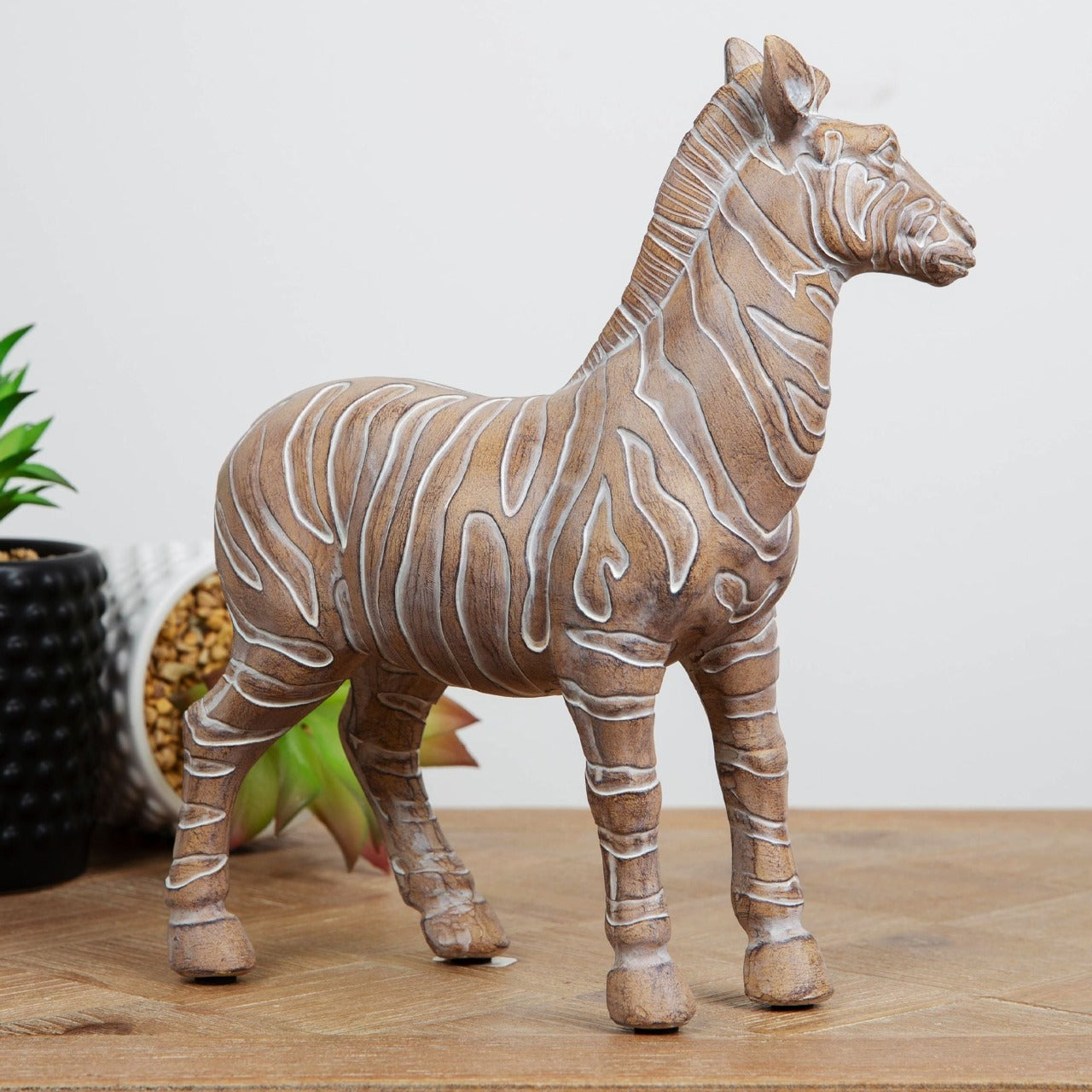 Embossed Zebra Figurine 23cm Bring some exotic vibes to your home with this carved sandstone effect resin zebra ornament. From the Global Artisan collection by HESTIA® - bring a touch of the exotic to your home.
