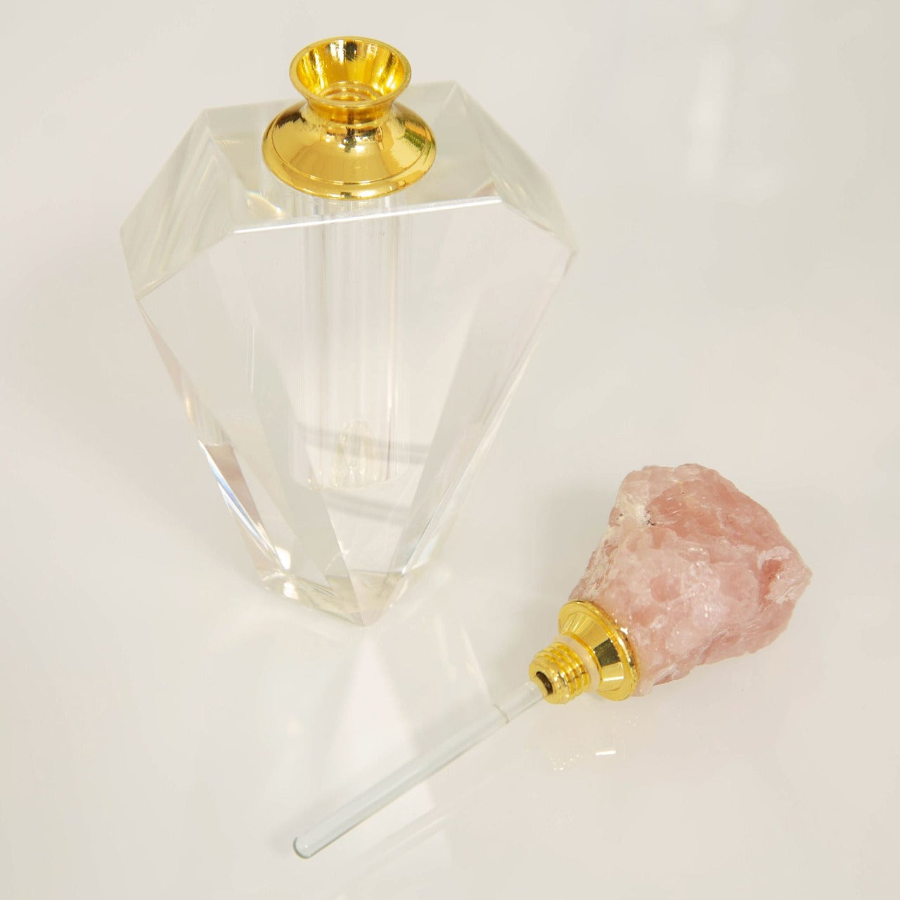 Estella Pink Stone & Glass Perfume Bottle A beautifully elegant cut crystal glass perfume bottle with pink rock crystal stopper top. From Estella by SOPHIA - Champagne Chic women's home and gift evoking the luxurious spirit of the art deco era.