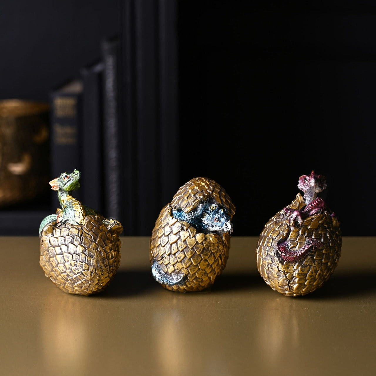 Fang Golden Dragon Egg Figurine A Fang golden dragon egg figurine by THE SEASONAL GIFT CO®. This majestic figurine captures the mythical world of dragons for those obsessed with fantasy.