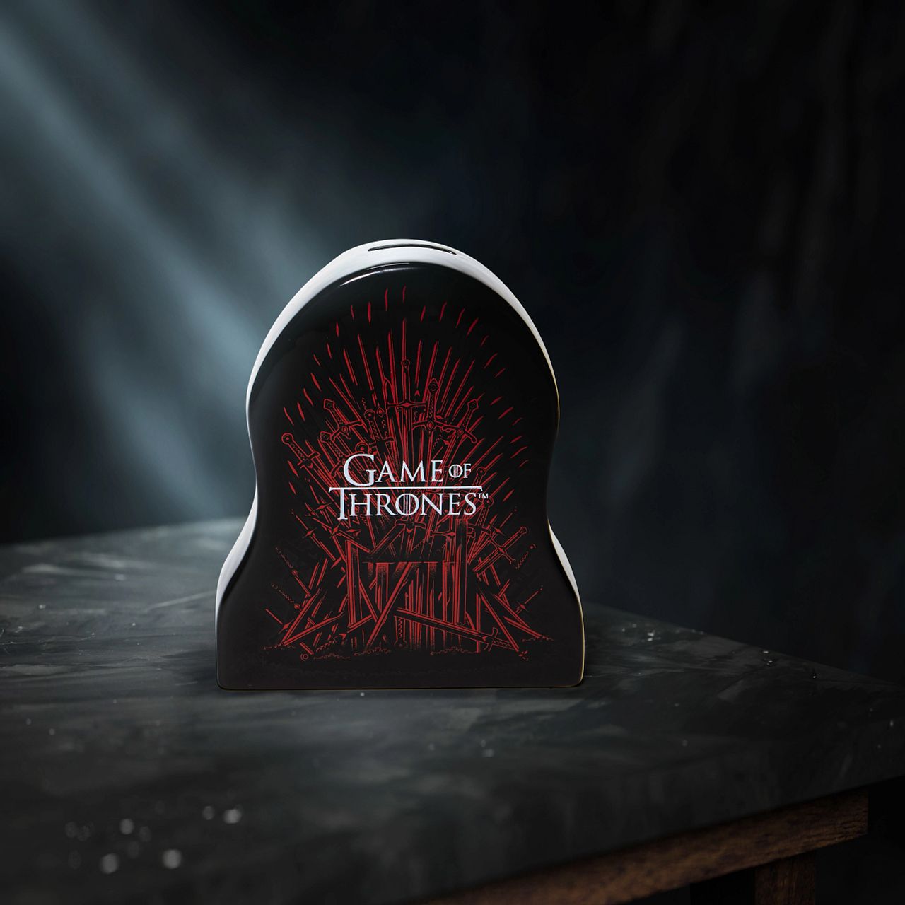 Department 56 Game of Thrones Iron Throne Ceramic Money Bank The Iron Bank will have its due… The Iron Bank may be the safest place for your money in Game of Thrones, but this ceramic bank is the next best thing for us. Featuring the iconic Iron Throne in black and red, with a glazed finish and minimalist shape, this is the perfect gift for anyone who is a Game of Thrones fan.
