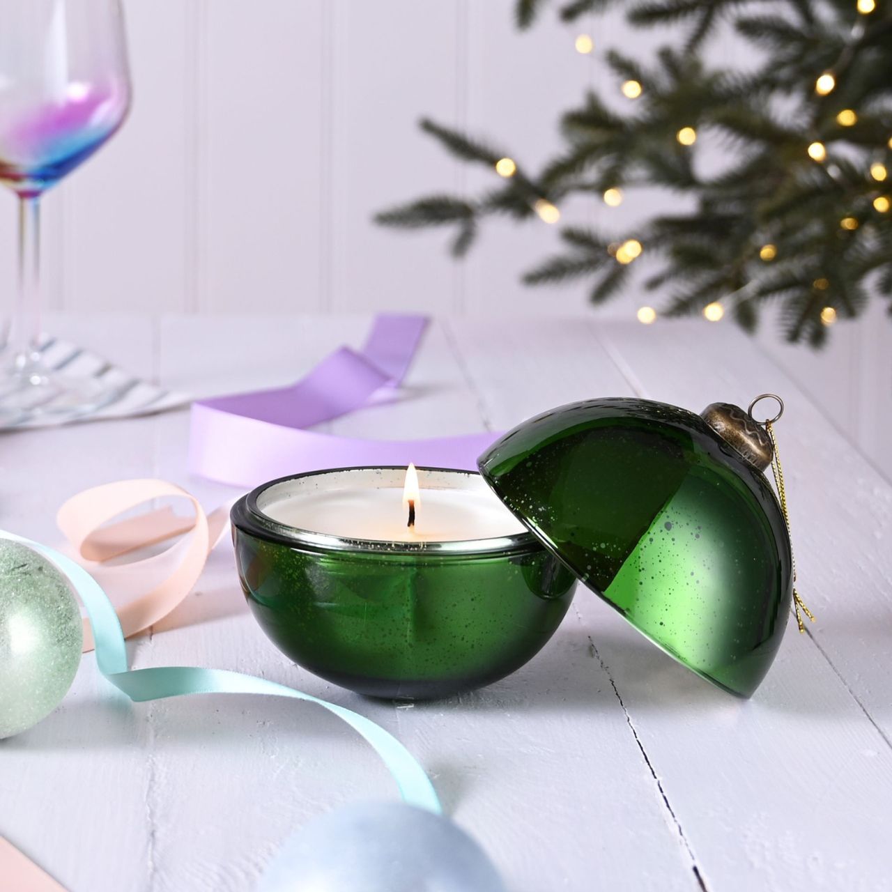 Green Holly & Fir Tree Fragranced Glass Bauble Candle A Holly & Fir Tree fragranced glass bauble candle. This aromatic candle makes an eye-catching addition to homes during the festive season.