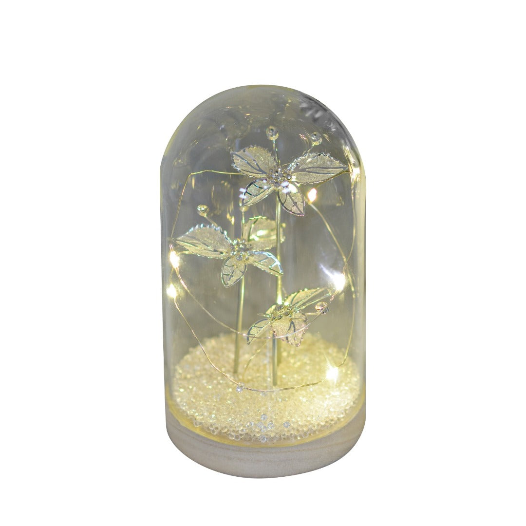 Jewel Butterfly Light Up LED Large Cloche An alluring LED cloche from HESTIA®'s Silver Luxe collection. Featuring 3 elegant butterflies with a jewel-covered wooden base. The HESTIA® Silver Luxe Collection brings clean, monochrome design to provide clean-cut elegance with mirrored glass and luxury glitter finishes supplying the glamour.