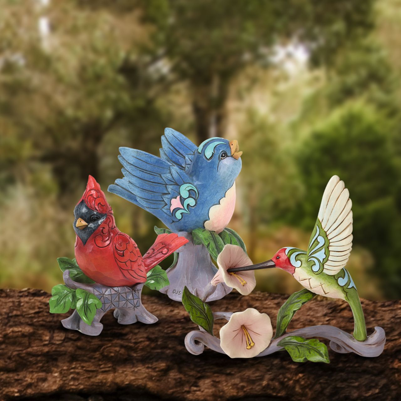Jim Shore Heartwood Creek Blossoms and Beauty - Hummingbird with Flower  A colourful accent to brighten your day, Jim Shore's richly detailed Hummingbird design features a combination of subtle quilt patterning and beautifully hand-crafted rosemaling motifs. Each Heartwood Creek piece is hand painted, crafted using high quality cast stone. Comes in a branded Kraft gift box.