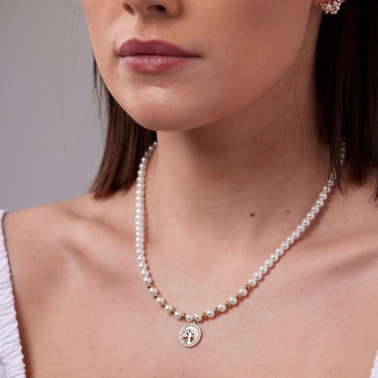 Tree Of Life Pearl Necklace by Knight & Day Knight & Day's Tree of Life Pearl Necklace is an exquisite piece of jewellery that features an intricate design.