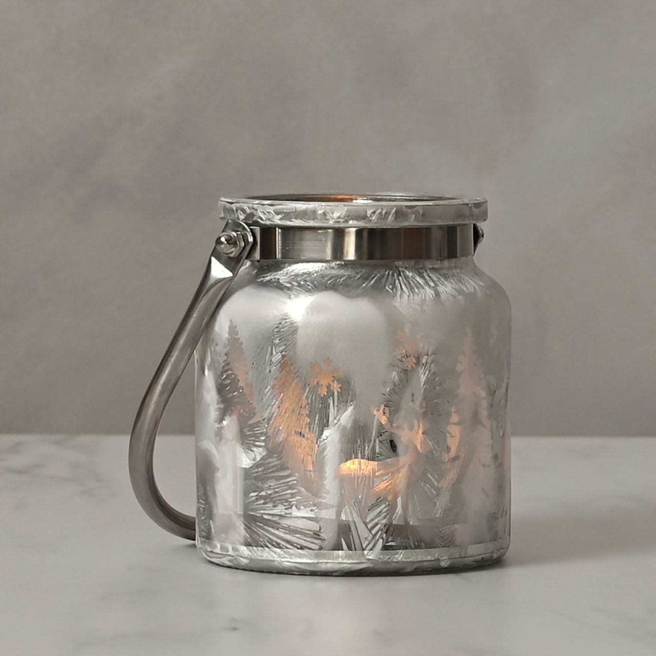 Christmas Frosted Reindeer Forest Scene Lantern with Handle A frosted reindeer forest scene lantern with handle. This enchanting lantern glistens with festive charm throughout the Christmas period.