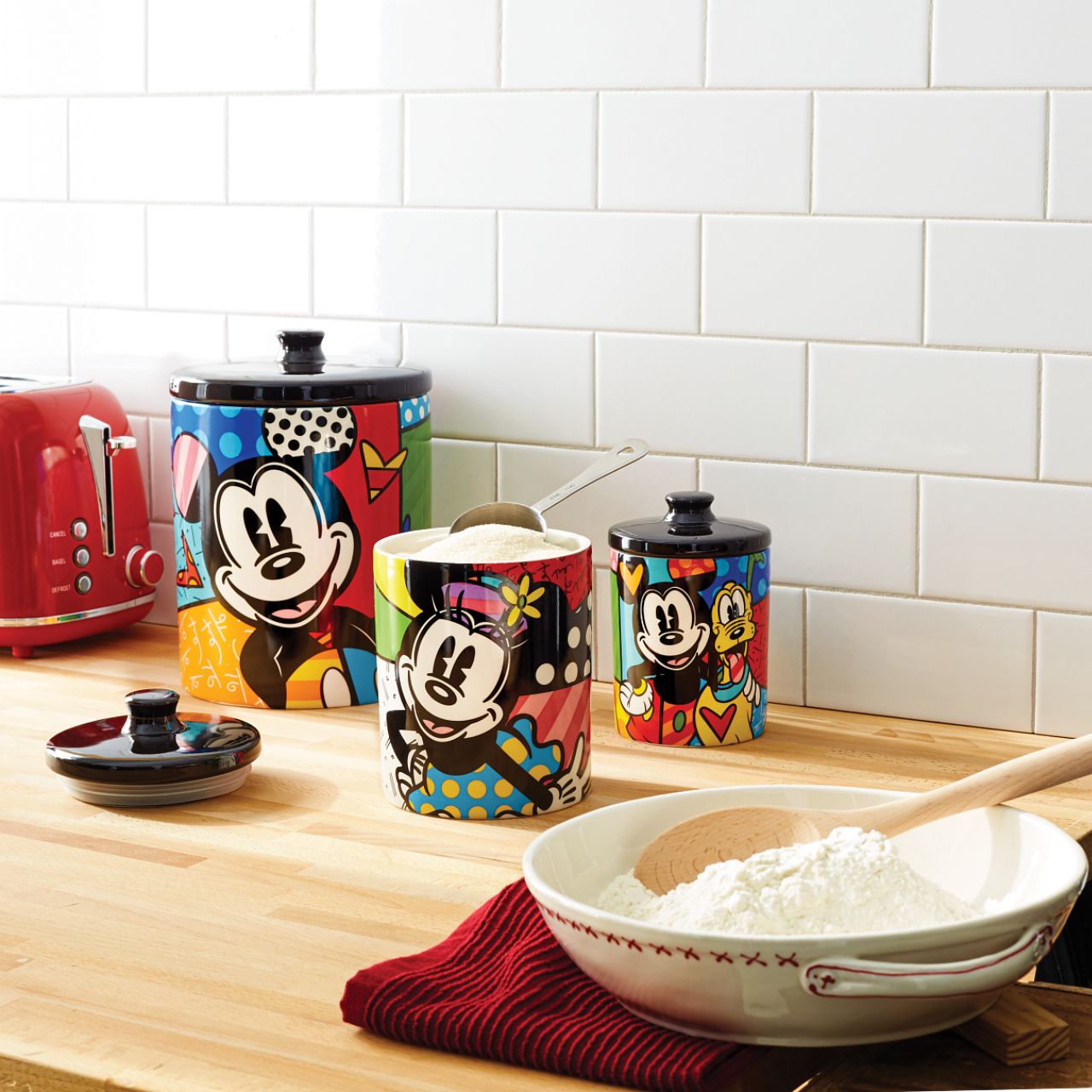 Mickey Mouse and Pluto Cookie Jar Small Mickey Mouse and his best pal Pluto are so full of life and love in this cookie jar canister designed by Romero Britto. Bright, bold, and full of friendship, it will be hard to avoid a sweet treat from such a sweet duo. Perfect for dog treats, coffee, flour, sugar or cookies.
