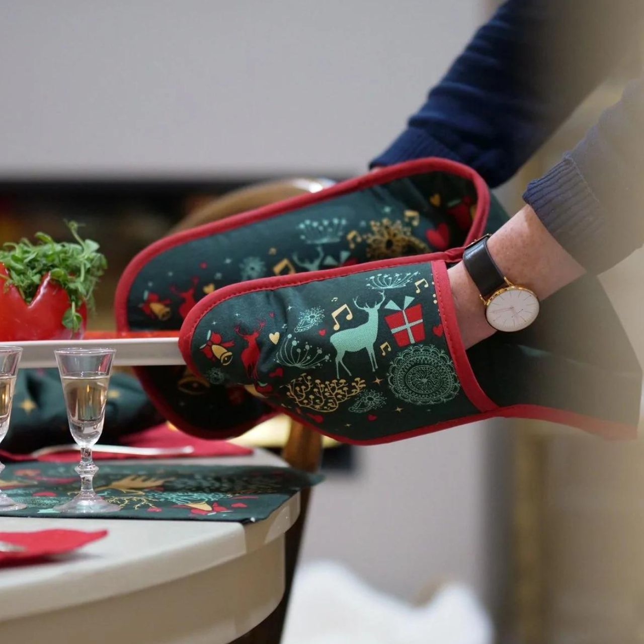 A Christmas Wish Double Oven Glove by Mindy Brownes Interiors A beautiful double oven glove finished in forest green with a Christmas design that depicts some of Christmas' key elements, such as reindeer, presents, music notes, and more.