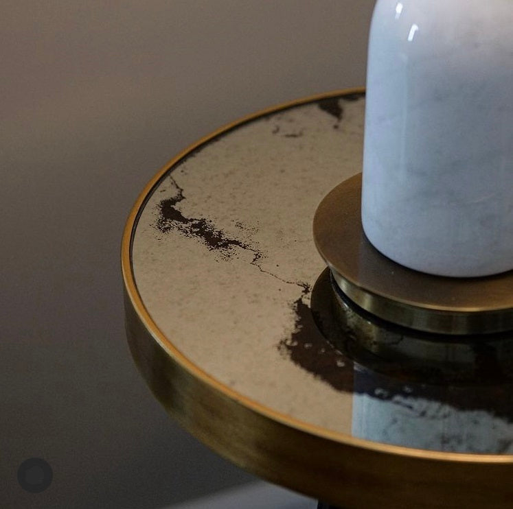 Mindy Brownes Vega Side Table Black painted leg with gold tip and surround, 37cm diameter side table, mirrored top with distressed grey swirl patterned top. Can be styled solo or as part of a collaboration with the Palm, Bellatrix & Venus side tables for the ultimate styling effect.