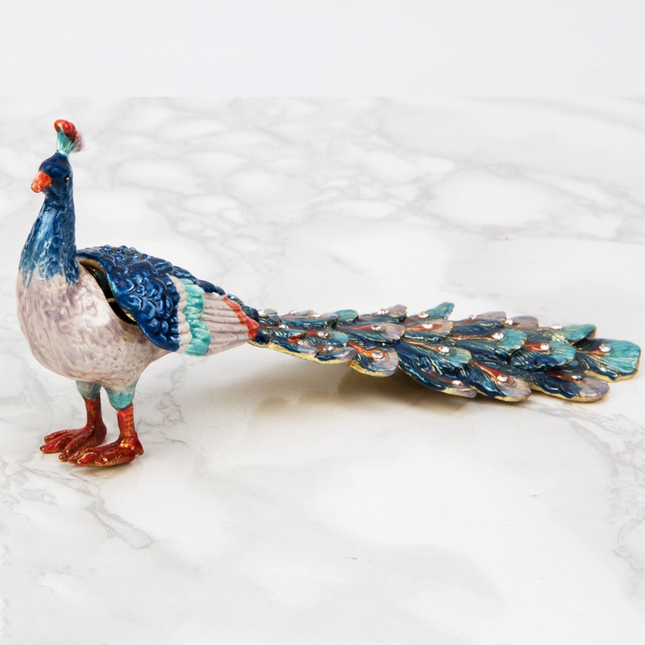 Treasured Trinkets - Peacock A beautiful, hand painted and crystal finished peacock trinket box from Treasured Trinkets. Painted with gorgeous blue plumage, this colourful trinket box is a wonderful ornament to complement a mantelpiece, bookcase or cabinet.