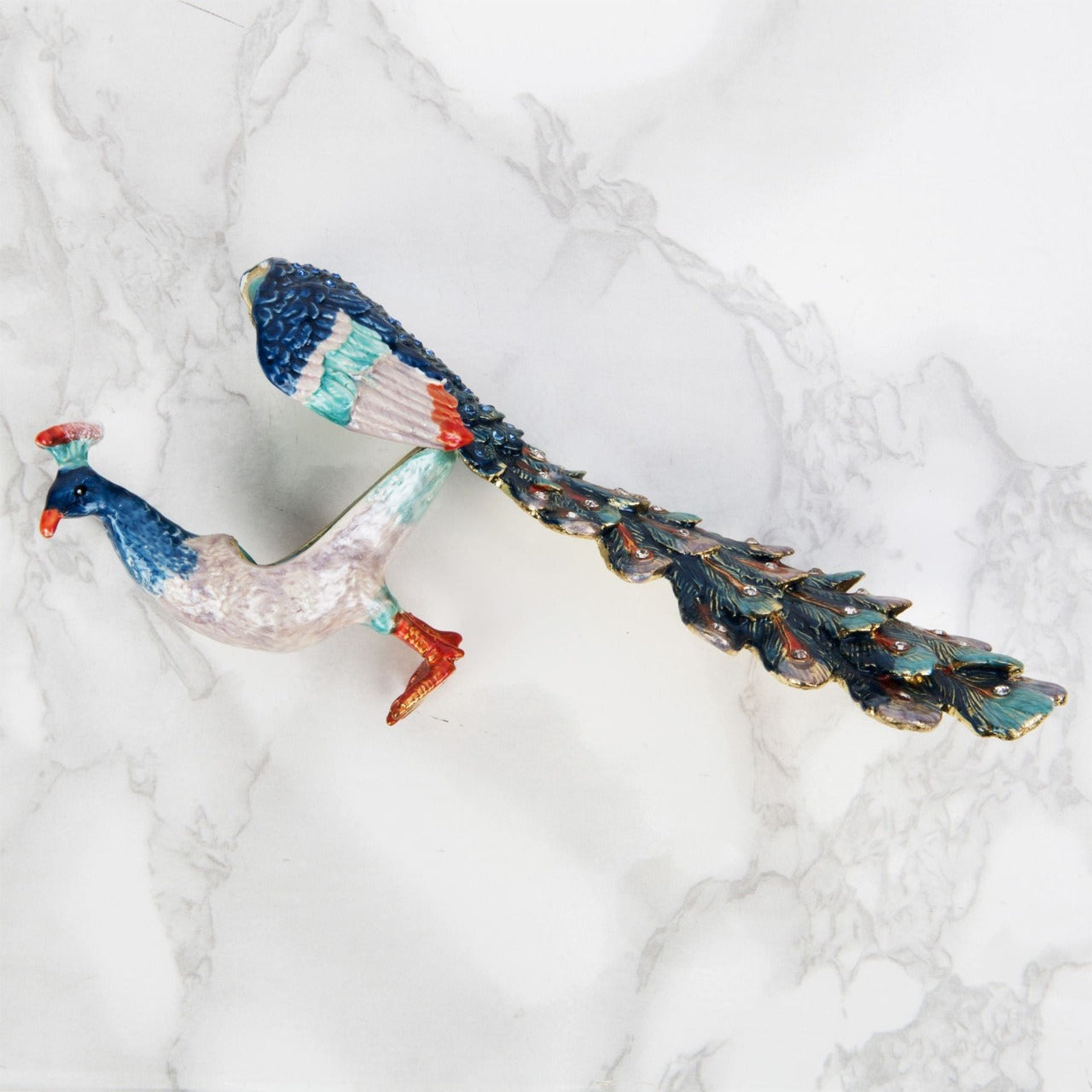 Treasured Trinkets - Peacock A beautiful, hand painted and crystal finished peacock trinket box from Treasured Trinkets. Painted with gorgeous blue plumage, this colourful trinket box is a wonderful ornament to complement a mantelpiece, bookcase or cabinet.