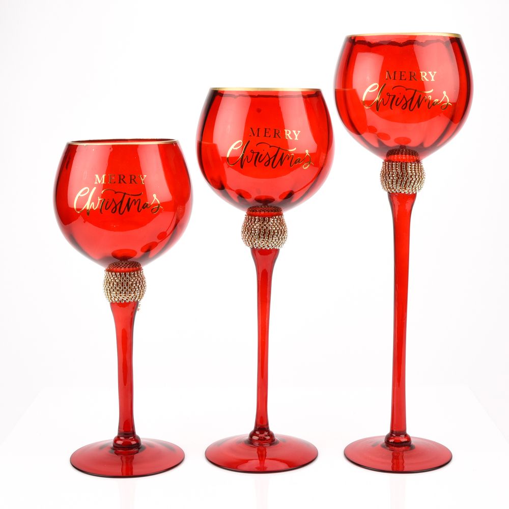 Red Glass Goblet Style Candle Holders Merry Xmas - Set of 3 A trio of red glass candle holdless feature a distinctive goblet design in three different sizes, complete with gold coloured embellishment around the neck and matching ‘Merry Christmas’ title.