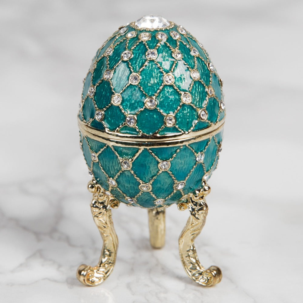 Treasured Trinkets Figurine - Small Turquoise Fabergé Egg A beautiful, hand painted and crystal finished Fabergé Egg style Trinket Box from Treasured Trinkets. Painted in a resplendent turquoise colour with stunning gold and crystal patterns, this trinket box is a wonderful ornament to complement a mantelpiece, bookcase or cabinet.