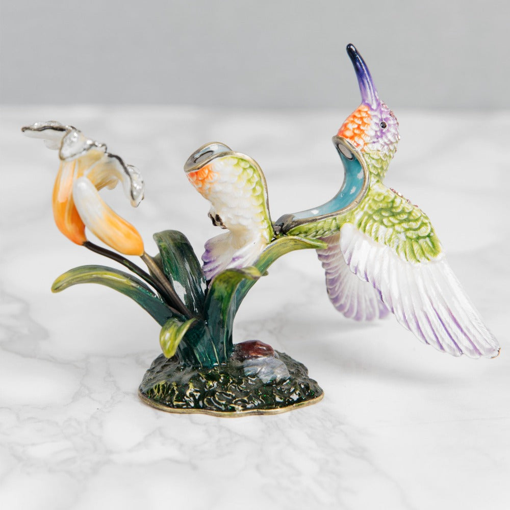 Treasured Trinkets Hummingbird A beautiful, hand painted and crystal finished hummingbird trinket box from Treasured Trinkets. Painted in the ethereal colours of a enchanting hummingbird, this trinket box is a wonderful ornament to complement a mantelpiece, bookcase or cabinet.