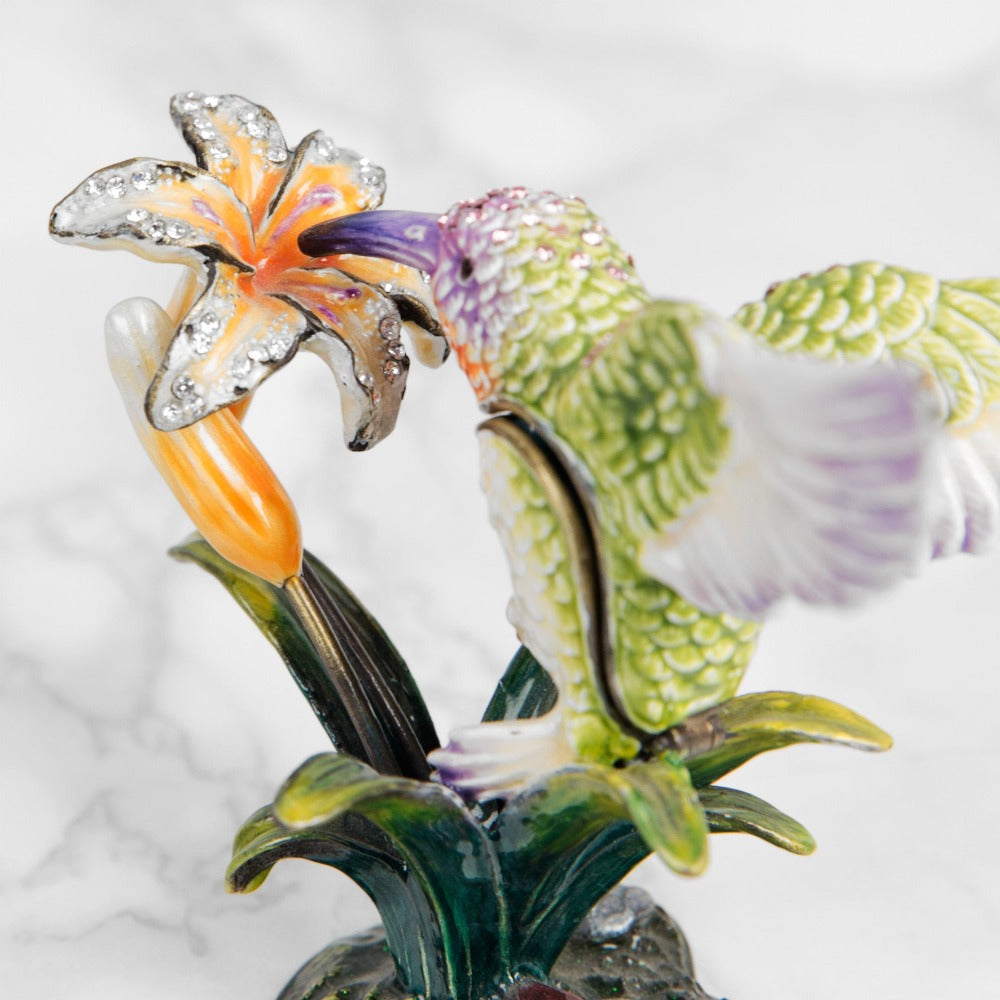 Treasured Trinkets Hummingbird A beautiful, hand painted and crystal finished hummingbird trinket box from Treasured Trinkets. Painted in the ethereal colours of a enchanting hummingbird, this trinket box is a wonderful ornament to complement a mantelpiece, bookcase or cabinet.