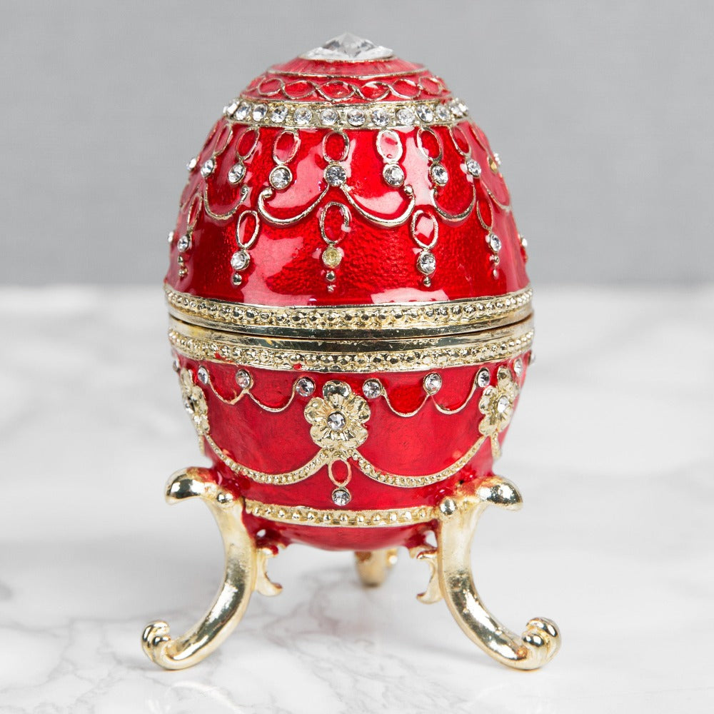 Treasured Trinkets - Large Red Fabergé Egg A beautiful, hand painted and crystal finished Fabergé egg trinket box from Treasured Trinkets. Painted in a majestic red colour with stunning gold and crystal patterns, this trinket box is a wonderful ornament to complement a mantelpiece, bookcase or cabinet.