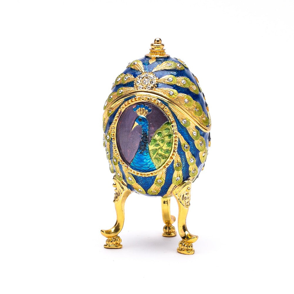 Treasured Trinkets Peacock Egg A beautiful, hand painted and crystal finished trinket box from Treasured Trinkets. Treasured Trinkets by Sophia is a collectable range of die cast metal trinket boxes, hand painted using colourful epoxy and finished with eye-catching crystals.