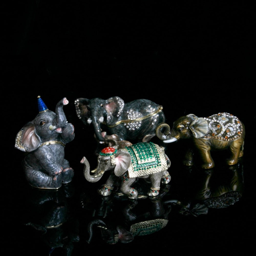 Treasured Trinkets - Elephant Curled Trunk A beautiful, hand painted and crystal finished elephant trinket box from Treasured Trinkets. Decorated with crystal patterns and floral embellishments, this colourful trinket box is a wonderful ornament to complement a mantelpiece, bookcase or cabine