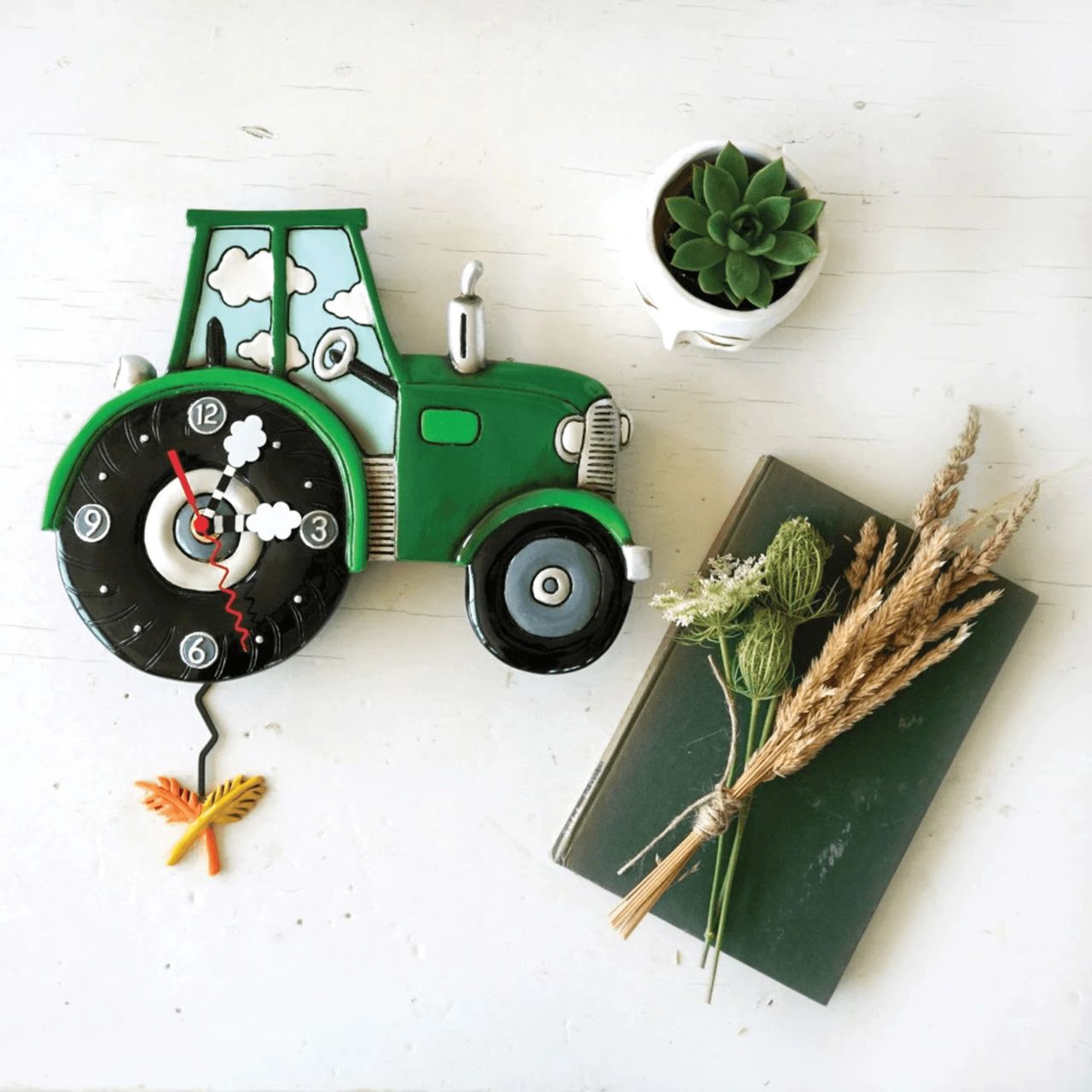 Harvest Time. Hope you love this green tractor clock as much as we do. The perfect, classic green, big back wheel, and silver tractor details give this clock so much character. Full of hand-painted details, this is a piece of art you'll to keep forever. Exclusively designed by Michelle Allen.