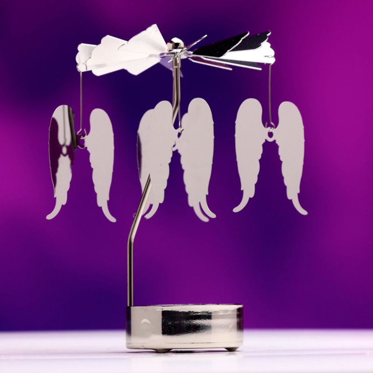 Illuminate any room with the stunning Angel Wings Rotating Carousel Spinning Tea Light Candle Holder. Made with delicate angel wings, this carousel spins gently while holding a tea light candle, creating a soothing and magical atmosphere. The perfect addition to any home décor.