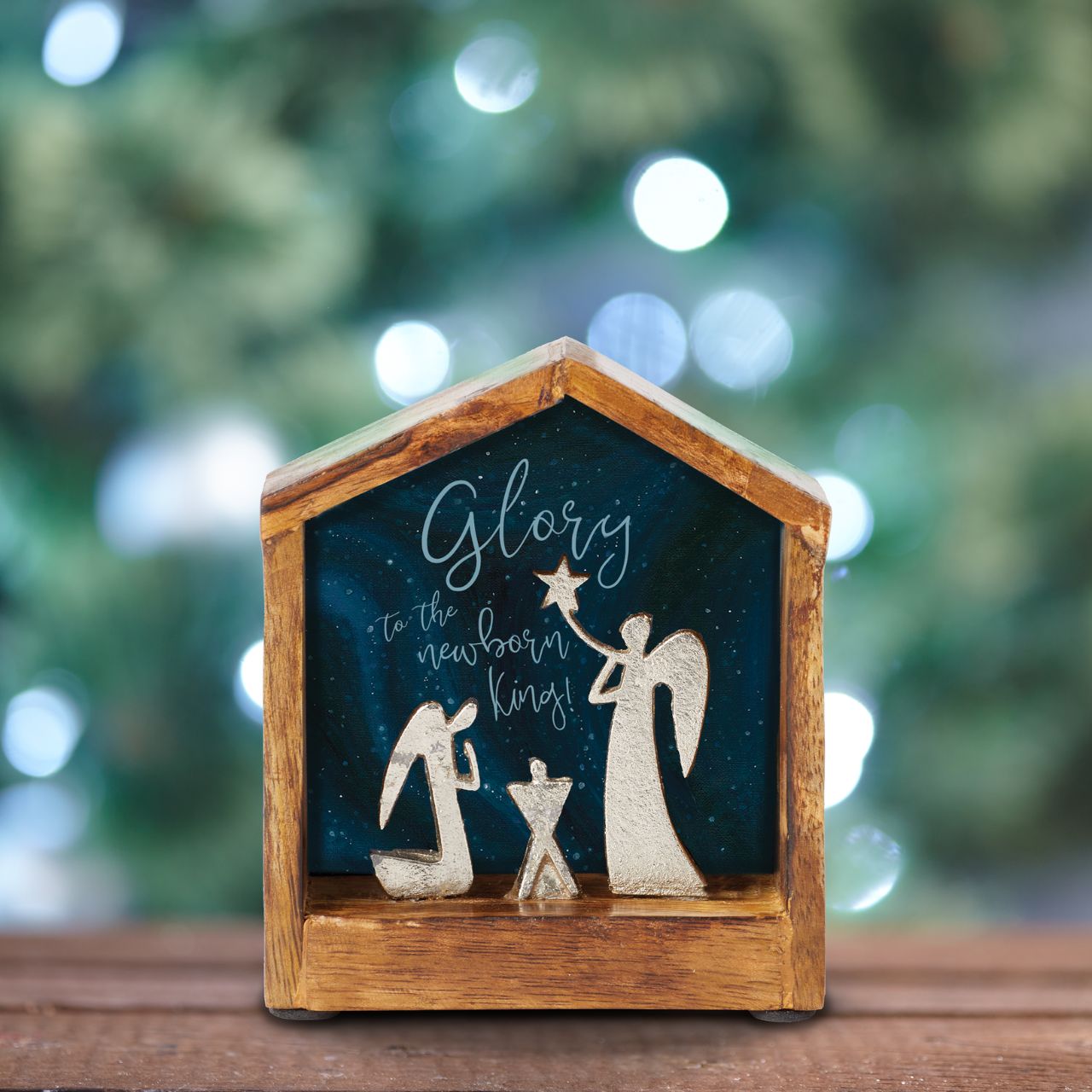 Artist, Wendy Wiinanen, crafts memorable and miniature traditional Christmas moments from mango wood and aluminium. This enchanting display places two angels in a wooden stable peering over a cradle.
