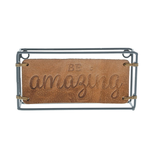 Be Amazing Plaque  The Impressions collection expresses appreciation of home and family in enduring leather creations. The Be Amazing Plaque adorns the home with an inspiring message. Made of iron and leather.
