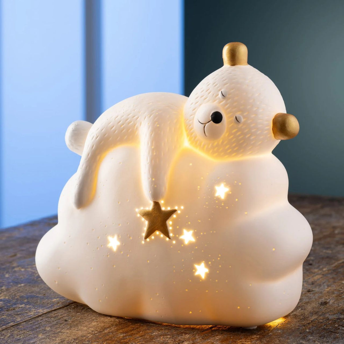 This cute luminaire features a little bear sleeping on a comfy cloud with star details and gold accents. When lit the porcelain body illuminates emitting a soft gentle glow highlighting all the details in this charming lamp, perfect for bedtime.