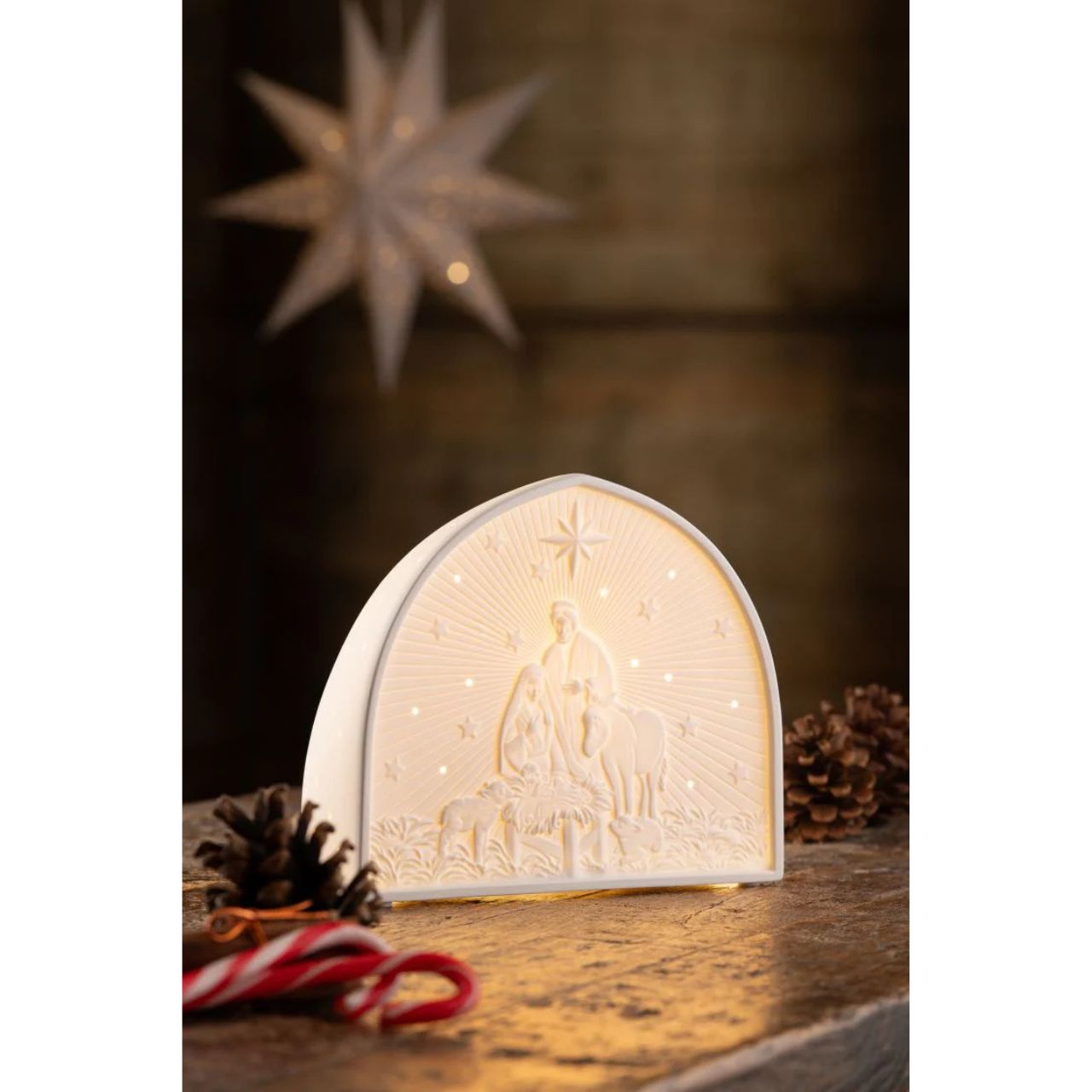 Decorative LED night light with Christmas scene on a wooden surface.