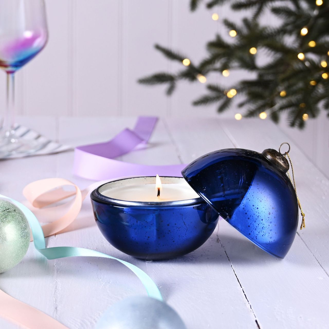 Blue Noel Fragranced Glass Christmas Bauble Candle  A Blue Noel fragranced glass bauble candle from THE SEASONAL GIFT CO.  This aromatic candle makes an eye-catching addition to homes during the festive season.