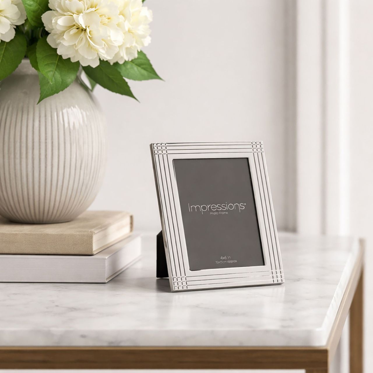 The Impressions Border Stripe Metal Plated Silver Photo Frame 4" x 6" offers a clean, contemporary way to display treasured photographs. Featuring a sleek silver-plated finish with subtle striped border detailing, it brings a refined touch to any home or office setting.