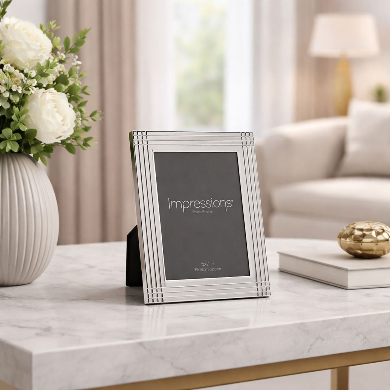 The Impressions Border Stripe Metal Plated Silver Photo Frame 4" x 6" offers a clean, contemporary way to display treasured photographs. Featuring a sleek silver-plated finish with subtle striped border detailing, it brings a refined touch to any home or office setting.