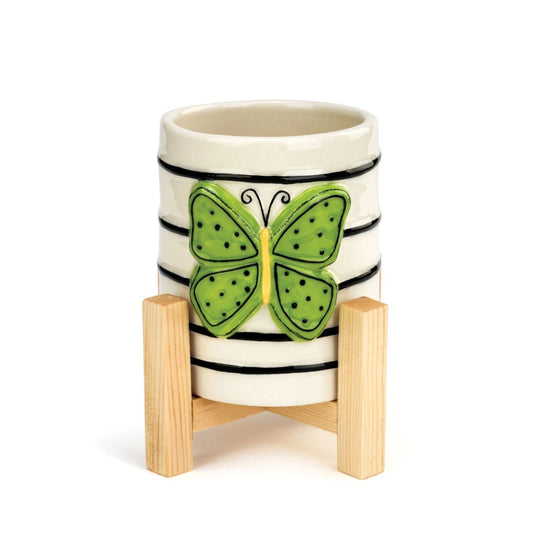 Tracy Pesche's Butterfly Mini Planter  Add a whimsical, happy touch to your home with Tracy Pesche's uplifting ceramic art. Her hand-painted Butterfly Mini Planter is a white planter with black rings and a bold green butterfly.