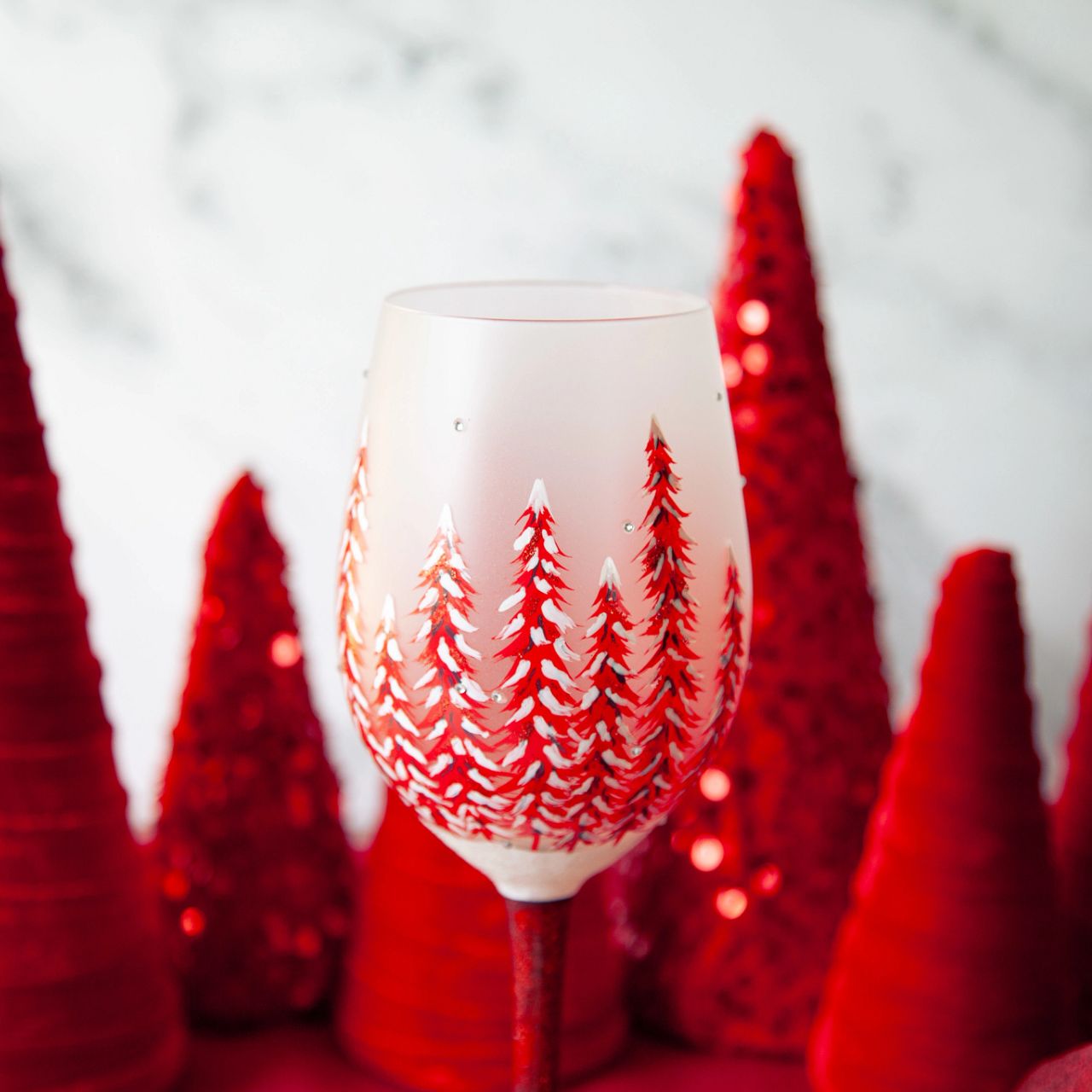 This gorgeous glass features a forest of red hand-painted pines covered in fresh fallen snow. With inlaid crystal snowflakes, this enchanting cup soothes with festive hue and sparkling elegance. Fill up you cup and give cheers to wintertime wonder.