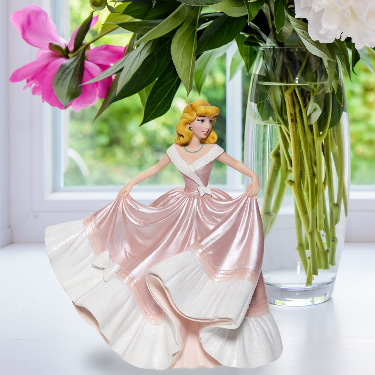 Cinderella in Pink Dress Couture de Force Figurine  Disney Couture de Force celebrates the 70th Anniversary of Cinderella. She is captured here in her classic pink gown of "what might have been." With the help of her mice tailors, the dress shimmers with satin finishes, iridescent glitter and jewels. Supplied in branded gift box.