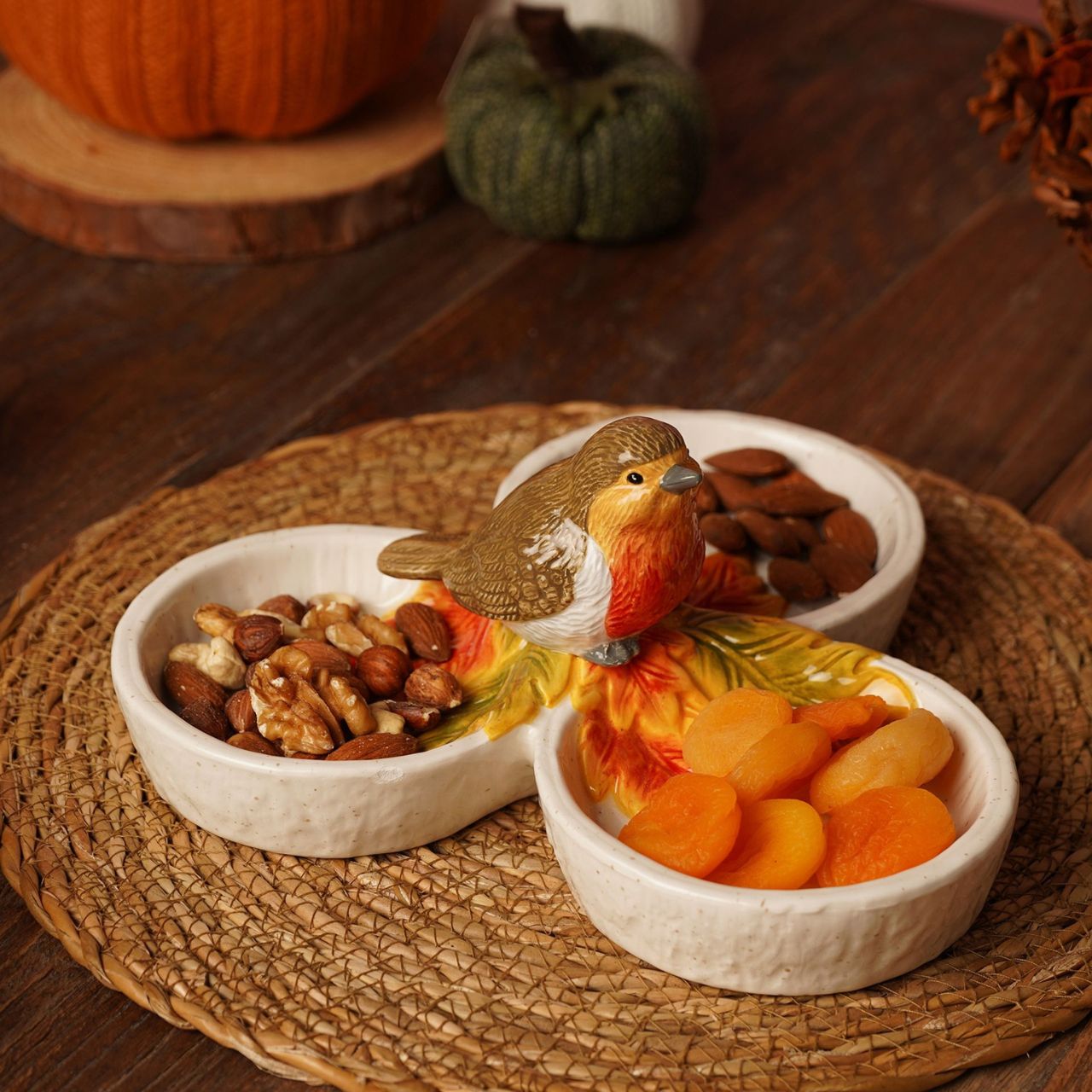 Featuring three connected dishes topped with a perched robin figurine, it’s ideal for serving seasonal nibbles like nuts, dried fruits, or sweets.